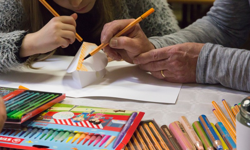 Une fille et son grand-père personnalisent la même maison en papier.