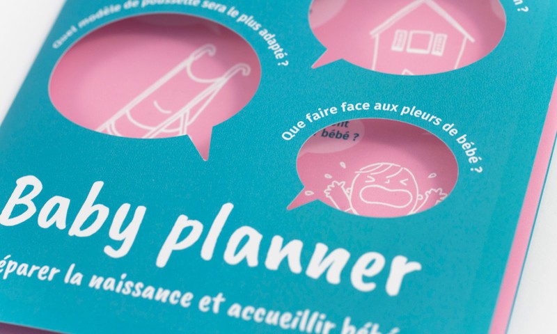 Vue de détail sur la première page du dépliant Baby planner, et sur les illustrations qui apparaissent à travers les ouvertures.