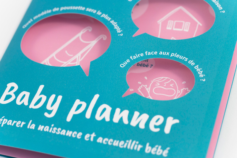 Vue de détail sur la première page du dépliant Baby planner, et sur les illustrations qui apparaissent à travers les ouvertures.