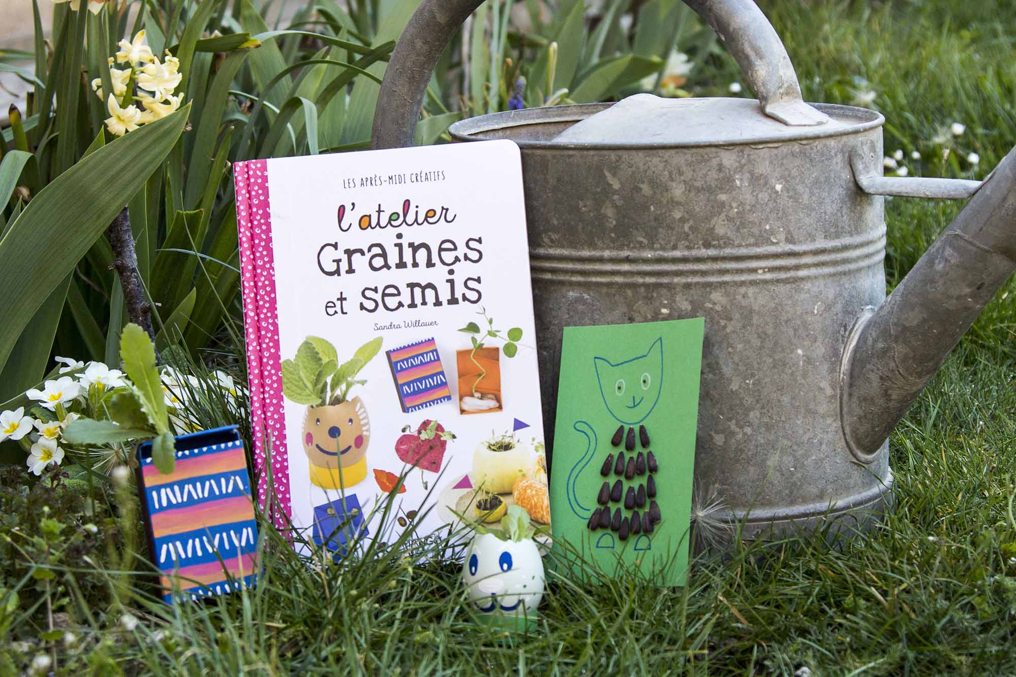 Aperçu du livre L'atelier Graines et semis dans le jardin avec quelques réalisations posées devant un arrosoir